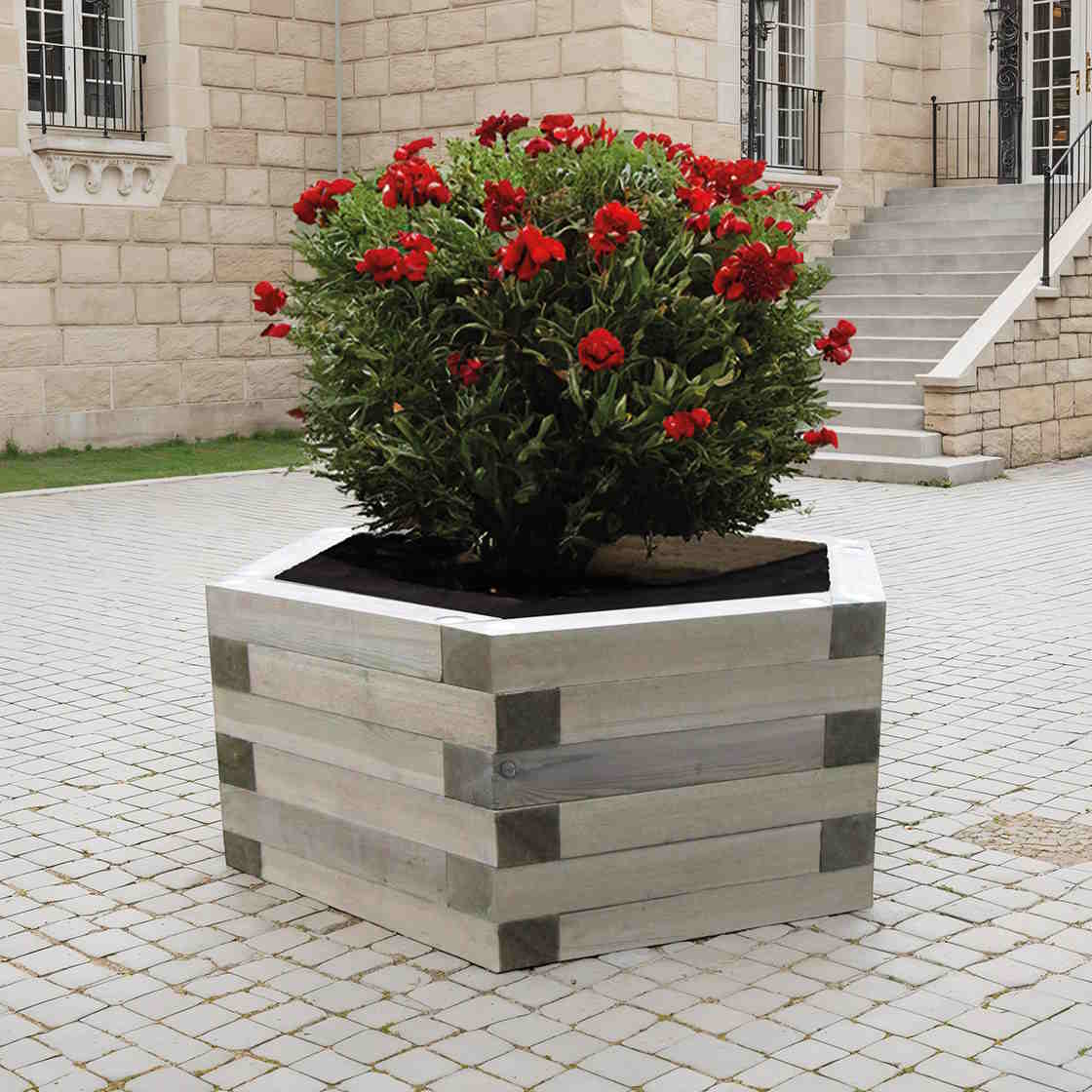 Bac hexagonal Turin en bois planté de rosiers sur une place pavée, mise en situation