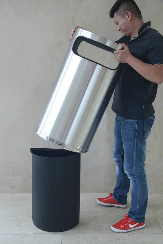 Poubelle demi-ronde inox placée contre un mur dans un hall d'accueil – France Collectivités